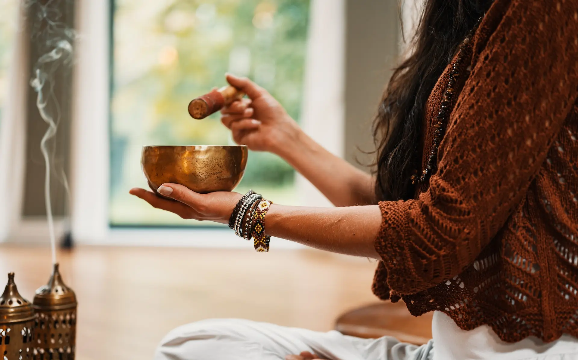 woman in brown knit sweater holding brown ceramic cup